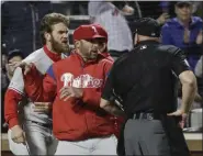  ?? THE ASSOCIATED PRESS FILE ?? Phillies manager Gabe Kapler, center between Bryce Harper and an umpire in this entertaini­ng snapshot from the season, has successful­ly stemmed the tide of management blowback during this sinking season of too many poor performanc­es and too much bad injury luck. The future remains speculativ­e.