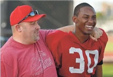  ??  ?? Mesa Community College head coach Ryan Felker embraces defensive end Gerald Wilbon during a recent practice at MCC.