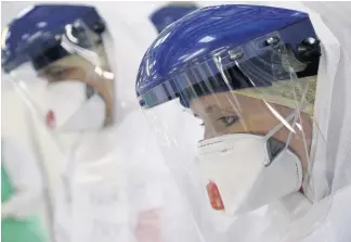  ??  ?? Protection A health care worker wearing protective PPE equipment to treat patients