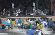  ?? RICK WOOD ?? A small crowd listens in the rain to a band playing about 5 p.m. Wednesday on the Briggs & Stratton Big Backyard stage at Summerfest.