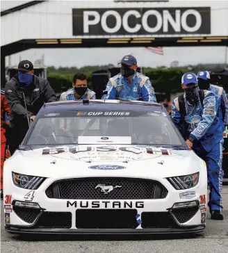  ?? MATT SLOCUM/AP ?? Crew members for Kevin Harvick his car to the starting grid before a scheduled NASCAR Cup Series auto race at Pocono Raceway on June 27 in Long Pond, Pa.