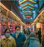  ?? MARK SCHIEFELBE­IN/AP ?? Shoppers eye souvenirs Feb. 28 in Beijing. China’s pandemic recovery and demand in India will drive 2023 growth in Asia, the Asian Developmen­t Bank said.