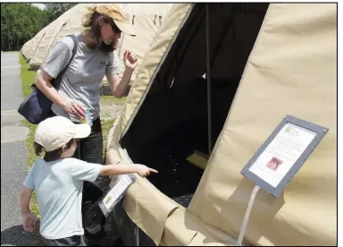  ?? (File Photo/aP/Wilson Ring) ?? Mary Russ and her son Siler look into a fish tank July 7, 2017, at the White River National Fish Hatchery following a ceremony marking the reopening of the hatchery, focused on producing landlocked salmon and lake trout eggs.