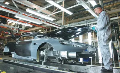  ??  ?? An employee works on an Aston Martin vehicle at the company’s factory in Gaydon in the United Kingdom.