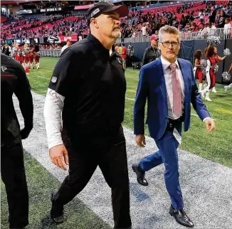  ??  ?? Falcons coach Dan Quinn, walking off the field with GM Thomas Dimitroff last Sunday, took over as defensive coordinato­r this season and has been getting heavy criticism for his team’s seeming lack of effort.