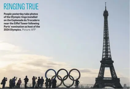  ?? Picture: AFP ?? People yesterday take photos of the Olympic rings installed on the Esplanade du Trocadero near the Eiffel Tower following Paris’ nomination as host of the 2024 Olympics.