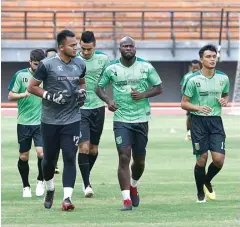  ?? GUSLAN GUMILANG/JAWA POS ?? MASIH TETAP: Para pemain Persebaya melakukan pemanasan sebelum memulai latihan rutin di Stadion Gelora Bung Tomo kemarin.