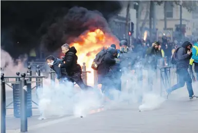  ?? CLAUDE PARIS, THE ASSOCIATED PRESS ?? People run away from a burning car during clashes in Marseille on Saturday.