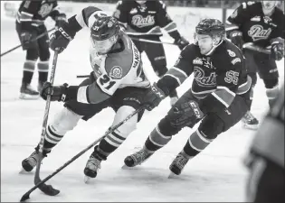  ?? Herald photo by Ian Martens ?? Lethbridge Hurricanes' Ryan Vandervlis tries to move the puck to the net past Regina Pats’ Liam Schioler during Game 4 of the WHL Eastern Conference finals Wednesday at the Enmax Centre.