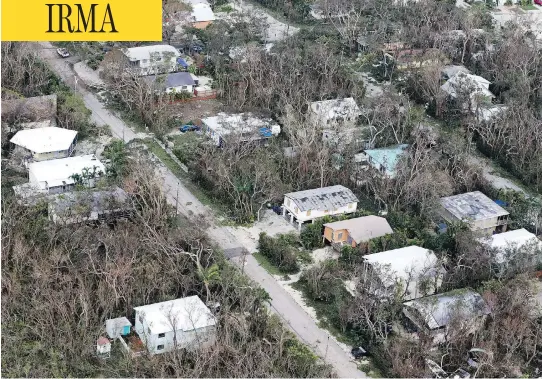  ?? WILFREDO LEE / THE ASSOCIATED PRESS ?? Damaged houses and trees stripped of foliage dot a residentia­l neighbourh­ood in Key Largo, Fla., in the aftermath of Hurricane Irma on Monday.