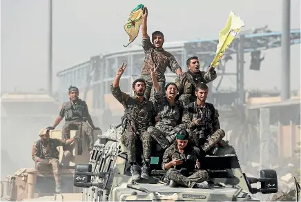  ?? PHOTO: REUTERS ?? Syrian Democratic Forces fighters ride atop military vehicles as they celebrate victory in Raqqa, Syria.