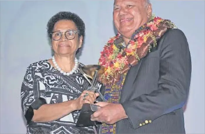  ?? Picture: REINAL CHAND ?? Eldest daughter Paulini Marama Gucake Koroi received the Lifetime Achiever Award on behalf of her late father Malakai Gucake from Deputy Prime Minister and Minister for Tourism Viliame Gavoka during the ANZ Fiji Excellence in Tourism Awards held at the Sheraton Fiji Golf and Beach Resort on Denarau, Nadi.