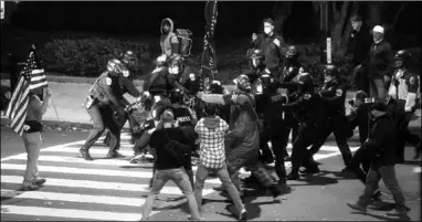  ??  ?? Law enforcemen­t personnel detain a person as supporters of US President Donald Trump clash with people opposing them on a street, in Washington. (Photo: AL Jazeera)