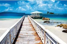  ??  ?? UNSPOILT: The Samana area of the Dominican Republic, which is good for whalewatch­ing. Right: The swimming pigs of the Bahamas. Below: A cafe sign in Jamaica