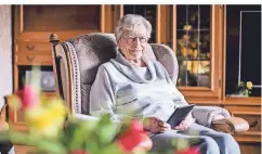  ?? FOTO: ANNE ORTHEN ?? Helga Hofmann gehört altersbedi­ngt zur Corona-Risikogrup­pe. Nun verbringt sie mehr Zeit mit ihrem E-Reader im Sessel.
