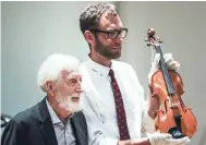  ?? THE COMMERCIAL APPEAL FILE ?? Stax founder Jim Stewart, left, stands with Jeff Kollath, executive director of the Stax Museum of American Soul Music, while showing off Stewart’s fiddle during a July 25, 2018, ceremony where Stewart donated his fiddle to the Stax Museum of American Soul Music.