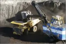  ?? THE ASSOCIATED PRESS ?? A mechanized shovel loads coal from an 80-feet thick seam into a haul truck at Cloud Peak Energy’s Spring Creek mine near Decker, Mont., on Nov. 15. Coal from the mine is shipped to power plants for generating electricit­y.