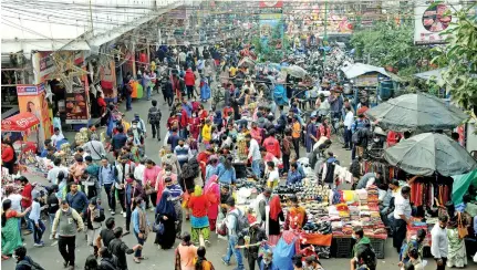  ?? Photo: Xinhua ?? People shop for decorative­s ahead of the Christmas festival, at New Market, in Kolkata on December 23, 2021.