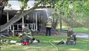  ?? Doug Walker / Rome News-Tribune ?? Battalion Chief Brad Beall mans the hose while a couple of firefighte­rs take a break battling a fatal house fire at 208 Turners Bend Road on Friday evening.
