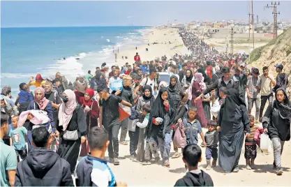  ?? ?? Palestinia­ns head up a coastal road in the hope of returning to their homes in the north of the strip
