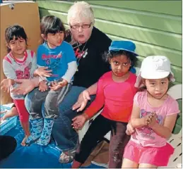  ??  ?? What couch?: Head teacher Keryn Doyle and kids from Barnardos asking: ‘Where’s our couch?’’