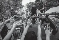  ?? Ezra Acayan / Getty Images ?? Residents are blessed by priests aboard a pickup to avoid the spread of the coronaviru­s in Manila, Philippine­s.