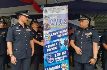  ?? ?? Ahsmon (second left) looks at a banner for the CMoS initiative. At second right is Kuching deputy police chief Supt Merbin Lisa.