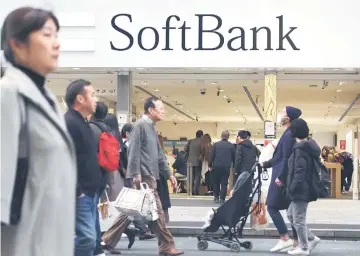  ??  ?? People walking in front of a shop of Japan’s telecoms giant SoftBank in Tokyo. In a statement, the group confirmed Monday it had formally decided to offer 1.76 billion shares, more than a one-third stake, in the SoftBank Corp mobile unit, with shares priced at 1,500 yen (US$13) each. – AFP photo