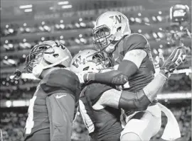  ?? Robert Reiners Getty Images ?? TAYLOR RAPP jumps into the arms of Washington teammate Psalm Wooching after making one of his two intercepti­ons to start the second half.