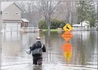  ?? CP PHOTO ?? A resident heads home at Darlings Island, N.B., on Thursday as the Kennebecas­is River flooded the only road into the community. Swollen rivers across New Brunswick are still rising, flooding streets and properties and forcing people from their homes in...