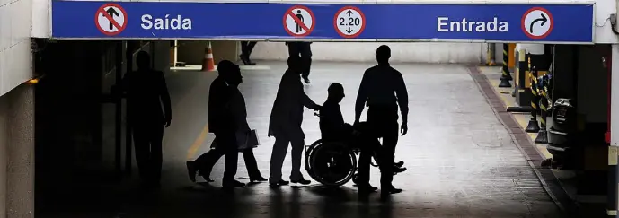  ??  ?? CONTROVERS­Y: Pat Hickey is escorted by police in a wheelchair at the Hospital Samaritano in Rio de Janeiro. Photo: Steve Humphreys