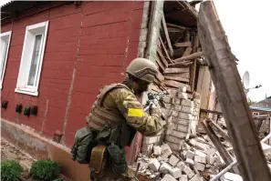  ?? The Associated Press ?? A Ukrainian serviceman patrols during a reconnaiss­ance mission in a recently retaken village on the outskirts of Kharkiv, east Ukraine, on Saturday.