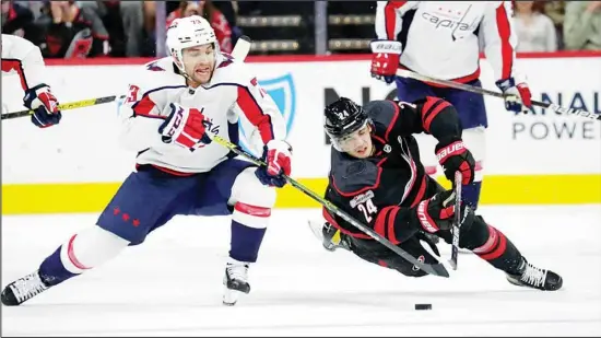  ?? ?? Washington Capitals left wing Conor Sheary (73) and Carolina Hurricanes center Seth Jarvis (24) go for the puck during the third period of an NHL hockey game in Raleigh, N.C. (AP)