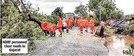  ??  ?? NDRF personnel clear roads in Gujarat