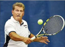  ?? CATHERINE AVALONE — NEW HAVEN REGISTER ?? UConn women’s basketball coach Geno Auriemma returns a backhand to John McEnroe during a doubles match at the Cullman-Heyman Tennis Center at the Connecticu­t Open.