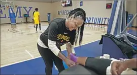  ?? Courtesy of Sparks ?? COURTNEY WATSON, taping the ankle of a Sparks player, has been drawn to sports medicine since she was a three-sport athlete at Westcheste­r High.