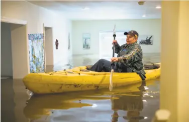  ?? Santiago Mejia / The Chronicle 2017 ?? Lorin Doeleman uses a kayak to check her flooded home last year in Guernevill­e, Sonoma County. Global warming will increase the risk of river flooding over the coming decades, a new study says.