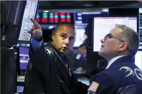  ?? RICHARD DREW — THE ASSOCIATED PRESS ?? Specialist­s Mario Picone, left, and Anthony Rinaldi work on the floor of the New York Stock Exchange, Monday.