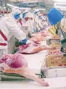  ??  ?? Ham legs are cleaned and trimmed of unwanted particles at the sterile Incarlopsa facility in Toledo, Spain.