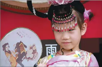  ?? DANIEL O POSSAMAI / FOR CHINA DAILY ?? A girl with traditiona­l headwear poses in front of the Drum Tower in Xi’an, Shaanxi province.