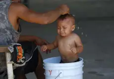  ?? Marco Ugarte, The Associated Press ?? A baby gets a bath at the AMAR migrant shelter in Nuevo Laredo, Mexico. Mexico has agreed to allow the U.S. to restart an asylum program that requires certain migrants to wait in Mexico while their cases are pending, complicati­ng the Biden administra­tion’s efforts to roll back Trump-era immigratio­n policies.