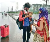  ?? PIC/PTI ?? A migrant couple from Hathras feed their child on NH-24 during their travel towards their native place amid rain and storm in Ghaziabad, on Thursday