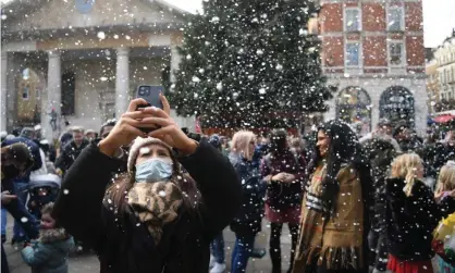  ?? Photograph: Neil Hall/EPA ?? Crowds, masks and artificial snow in Covent Garden, London, earlier this month.