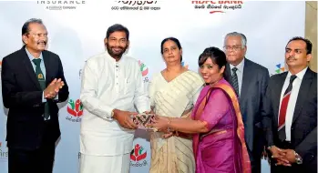  ??  ?? Social Welfare and Primary Industries Minister Daya Gamage handing over a letter to one of the beneficiar­ies of ‘Rathnabhim­ani’ pension plan. HDFC Bank Chairman R.J. De Silva is also in the picture