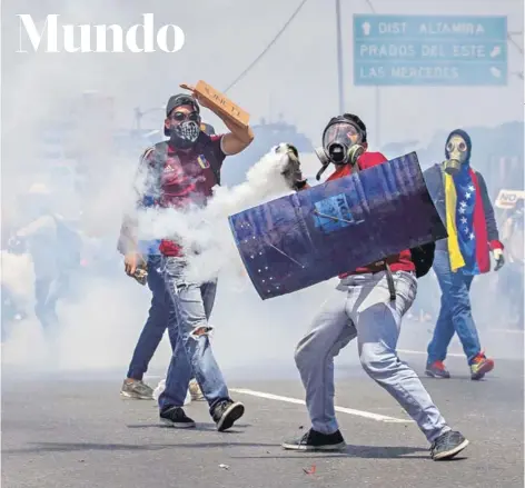  ?? FOTO: EFE ?? ►► Manifestan­tes se enfrentan a las fuerzas de seguridad ayer en Caracas.