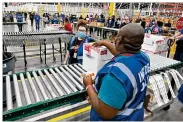  ?? TIMOTHY D. EASLEY / POOL ?? The first box containing the Johnson & Johnson COVID-19 vaccine heads down the conveyor to an awaiting transport truck at the McKesson facility Monday in Shepherdsv­ille, Ky.