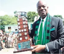  ?? FILE ?? Calabar High School principal Albert Corcho poses with the Mortimer Geddes Trophy after his school claimed its sixth-straight ISSA/ GraceKenne­dy Boys’ Athletic Championsh­ips title.