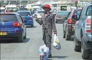  ?? TSVANGIRAY­I MUKWAZHI / ASSOCIATED PRESS ?? Farai Mushayadem­o, a street vendor, sells water and chips in Harare, Zimbabwe.