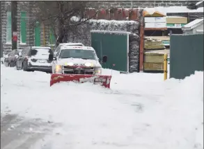  ??  ?? A plow clears snow from South Water Street in Byram.