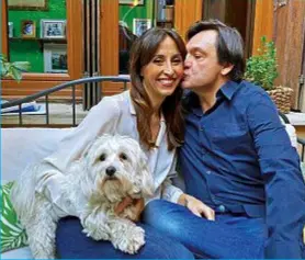  ??  ?? Milano. Fabio Caressa, 52, e Benedetta Parodi, 47, nel loro appartamen­to di Milano. Qui a fianco sul balcone, col loro cane. Sopra mentre tentano di completare un puzzle. A sinistra, Fabio cucina la pasta alla norcina, la sua specialità.